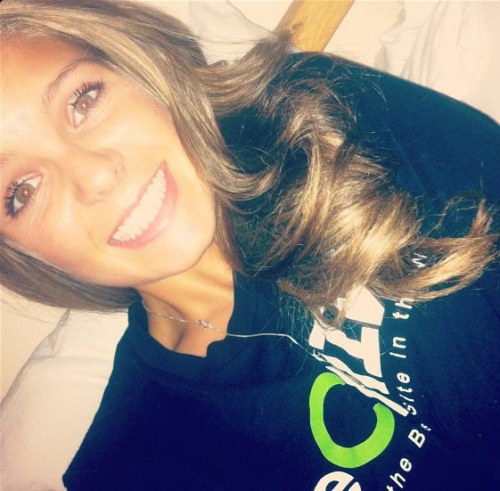 Pretty light-eyed blonde with wavy flowing tresses and juicy lips smiles for selfie in black theChive top