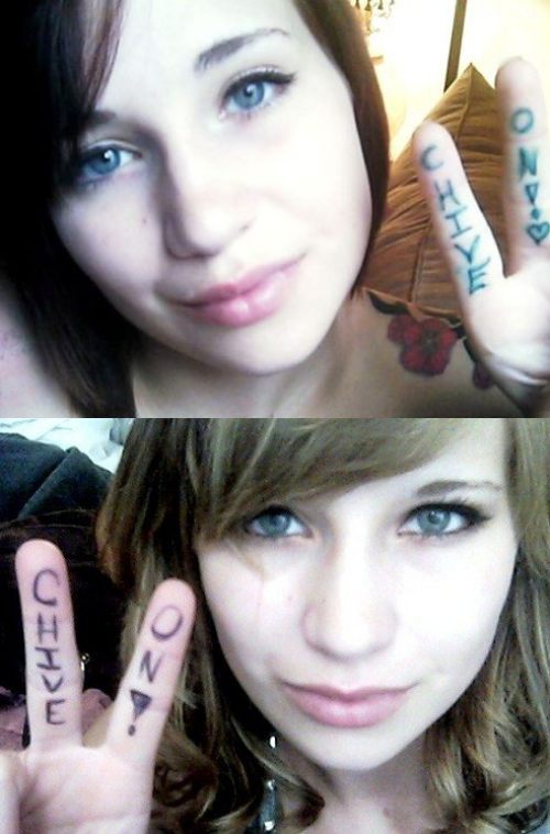 Pretty brunette with gray eyes, juicy lips, and Chive On written on fingers poses for selfie