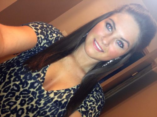 Pretty light-eyed brunette with flowing tresses takes selfie in cleavage showing leopard print black/beige top