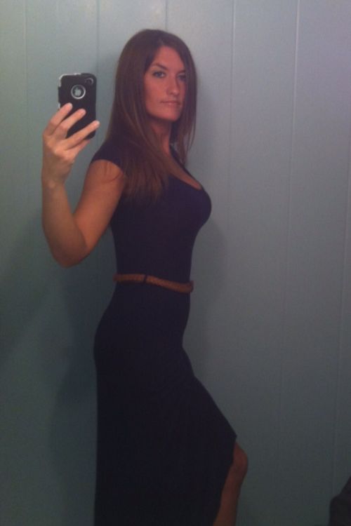 beautiful lady with black long flowing hair clicks a selfie in black full one piece outfit.