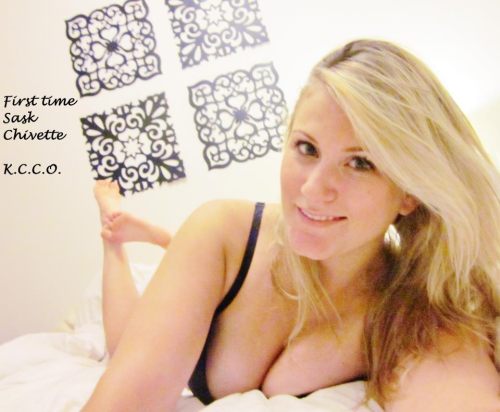 blonde lady in black bra laying on her belly on her bed exposes her big boobs