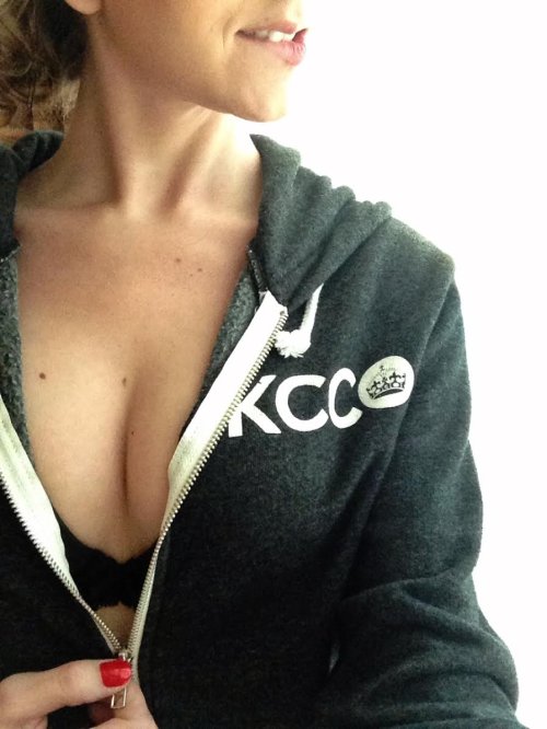 Blonde takes selfie in black bra and cleavage showing black KCCO jacket