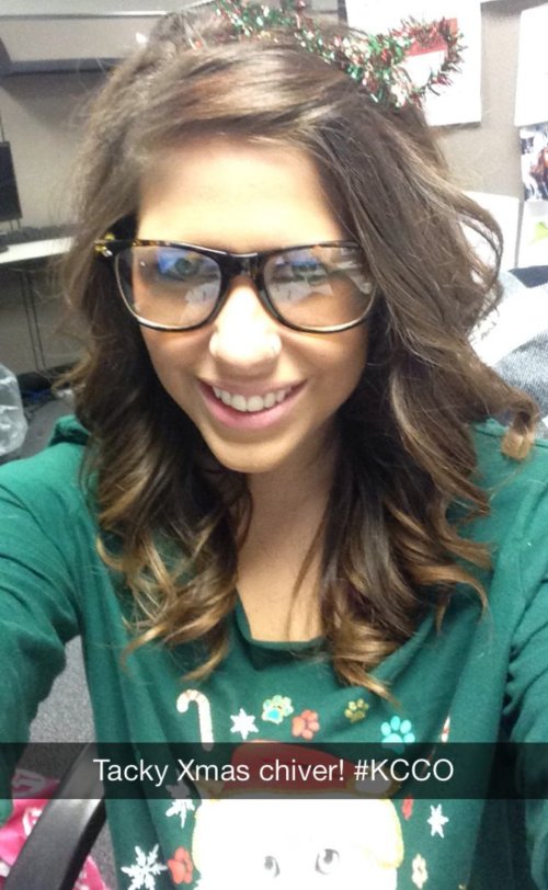 Brunette smiles for selfie in glasses and green top