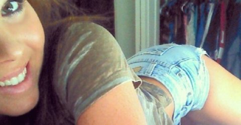 girl laying with butt up in blue jean shorts