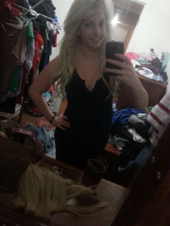 Pretty blonde with supple sexy hot body takes selfie in black dress in a messy room