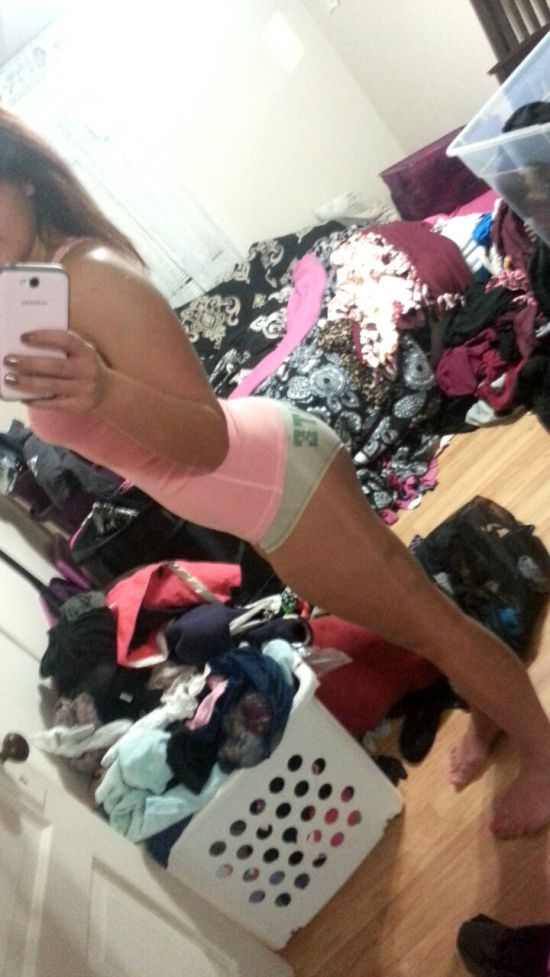 Brunette with perky juicy boobs and booty, flat abs, slender legs, and sexy hot body takes selfie in pink top and grey panties