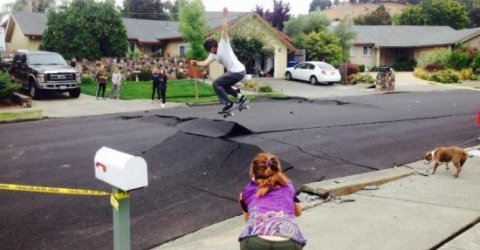 Guy skateboarding on big crack in the street