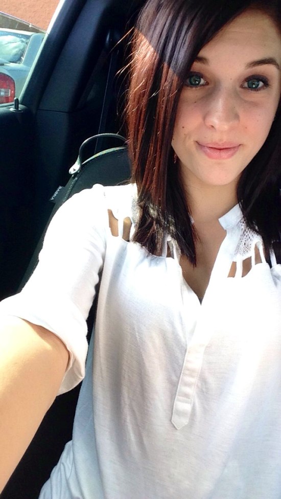 car selfie of girl in white shirt and short brown hair