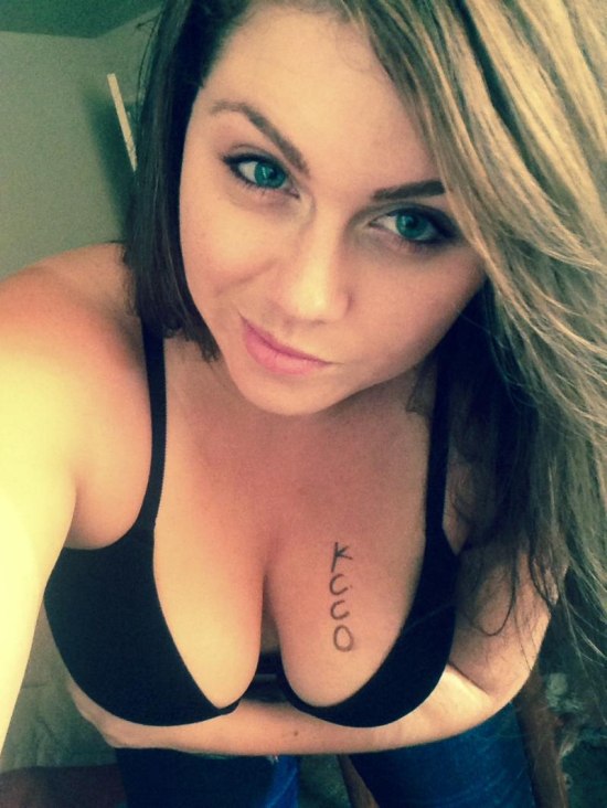 selfie of girl in black bra with KCCO on her boob