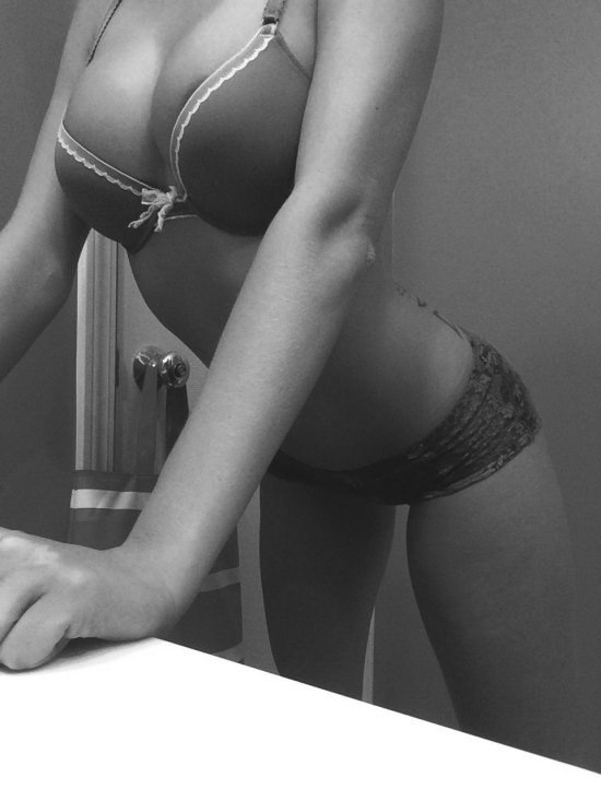 black and white photo of girl leaning against counter in underwear