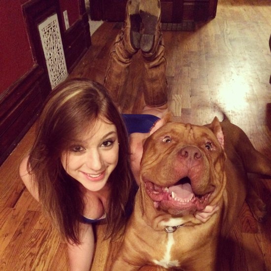 Girl with cleavage showing posing with a pitbull