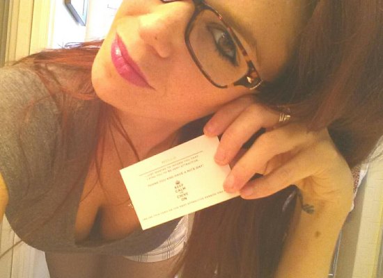 cute girl in glasses holding KCCO card showing cleavage