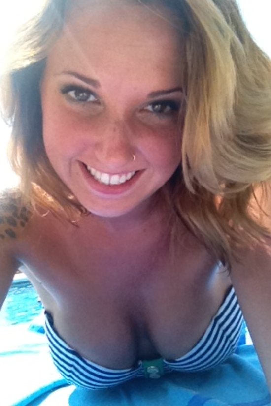 girl in striped bikini laying on towel showing cleavage