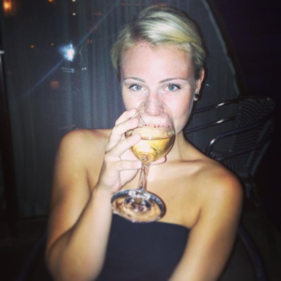 blonde girl in black tube top drinking wine