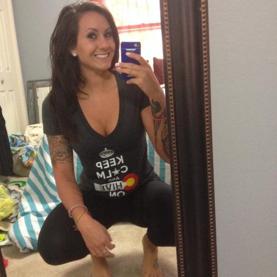Mirror selfie of girl with tattoos wearing KCCO shirt on