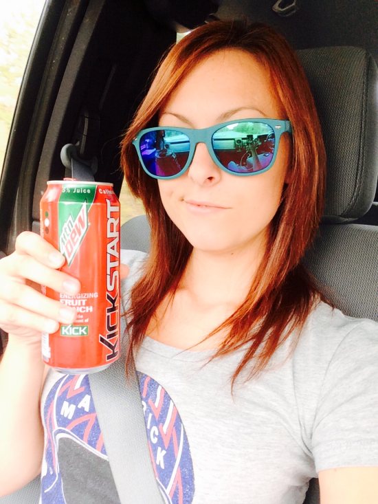 Girl in blue sunglasses drinking a kickstart energy drink