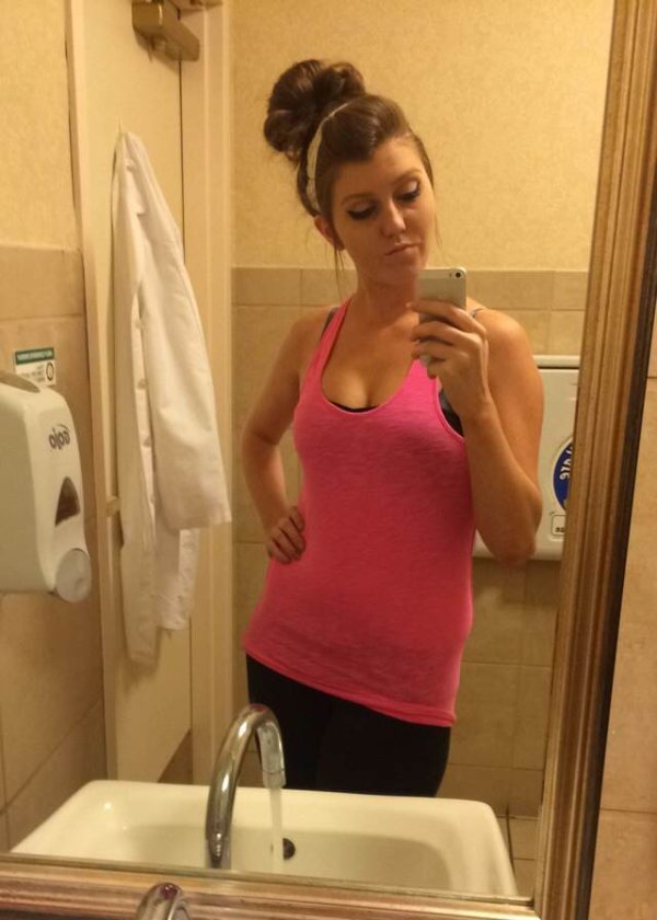 Young girl takes her mirror selfie wearing pink sleeveless top