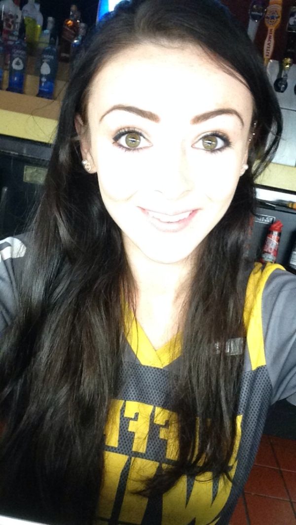 Girl with black hair and grey and yellow jersey