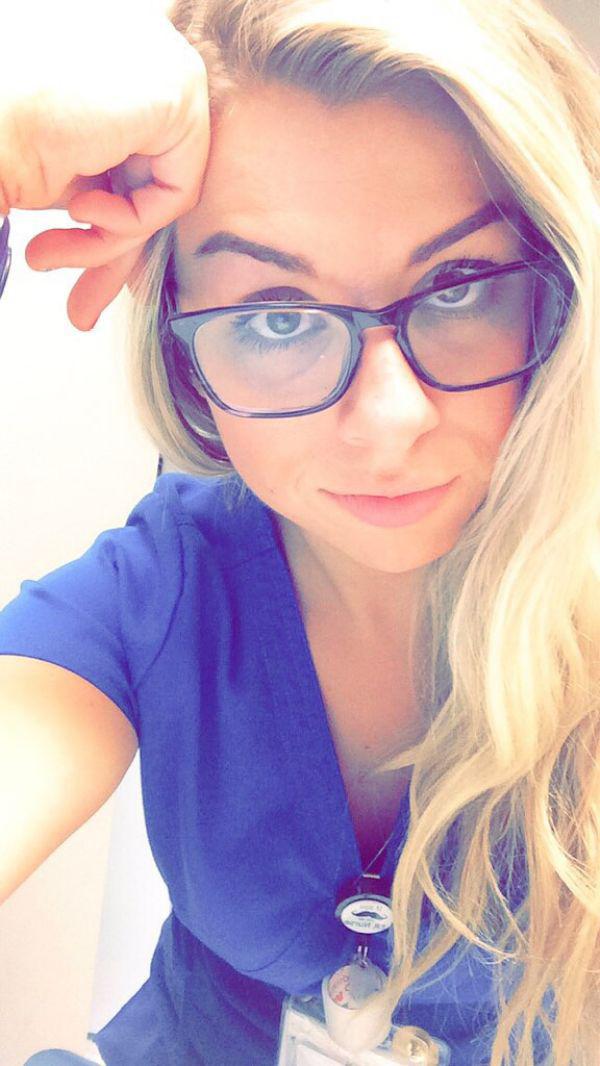 Pretty blonde with full lips and perky boobs takes selfie in glasses and blue nurse/doctor uniform