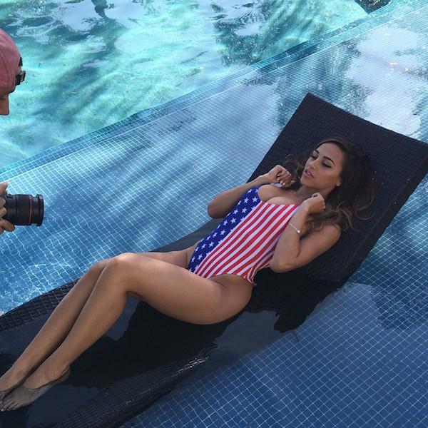 Pretty brunette with perky juicy boobs, slender long legs, and slim sexy curvy hot body poses in pool on float in stars and stripes swimsuit