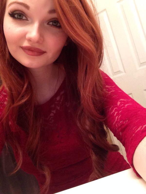Pretty light-eyed redhead with plump red lips and perky tits takes selfie in red lace dress
