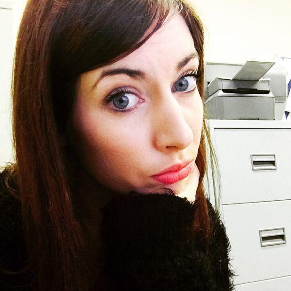 cute working lady clicks bored selfie at desk with caption - IS IT FRIDAY YET???