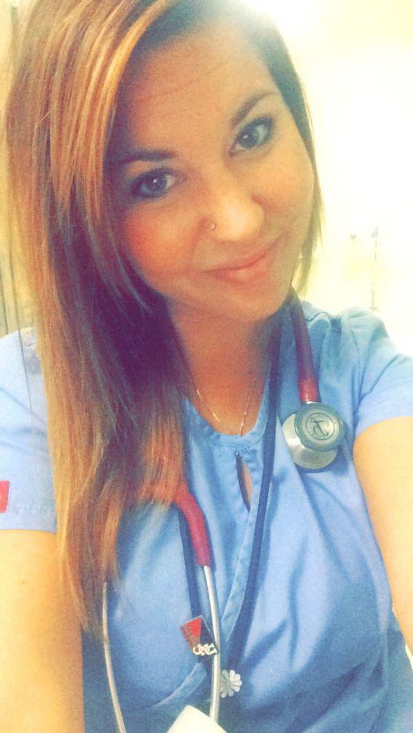 beautiful female doctor clicks lovely smile selfie in blue office dress with stethoscope in neck