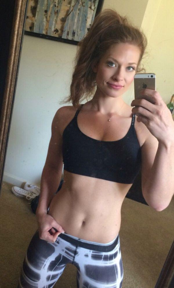 Brown-haired beauty takes a selfie, wearing a black bra, showing off her perfect abs
