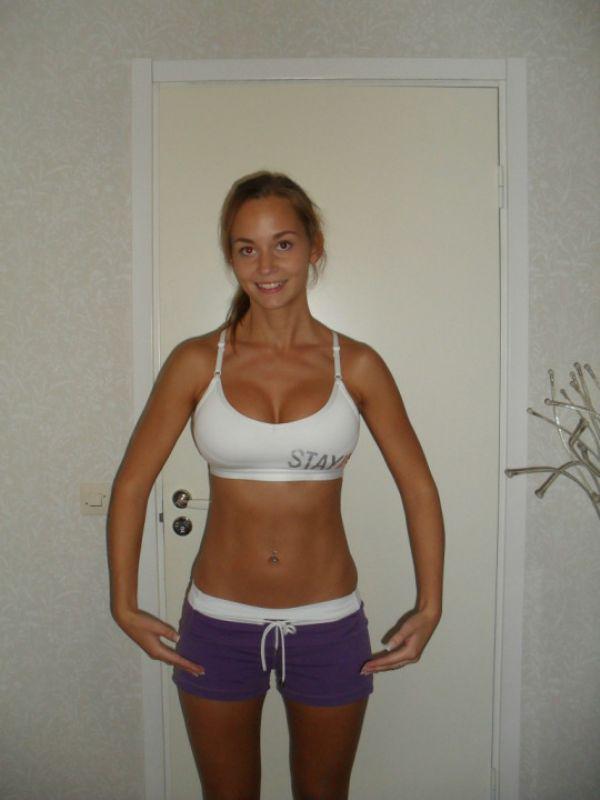 Sexy babe shows off her perfect figure in white sports bra and dark blue shorts