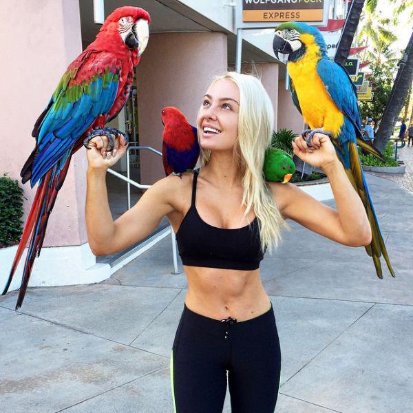 Sexy babe looks photogenic with replicas of colored parakeets.