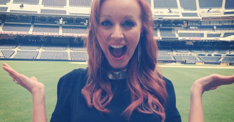 pretty girl Lindy booth poses with surprise facial expression wth a wide open mouth in a lush green playground