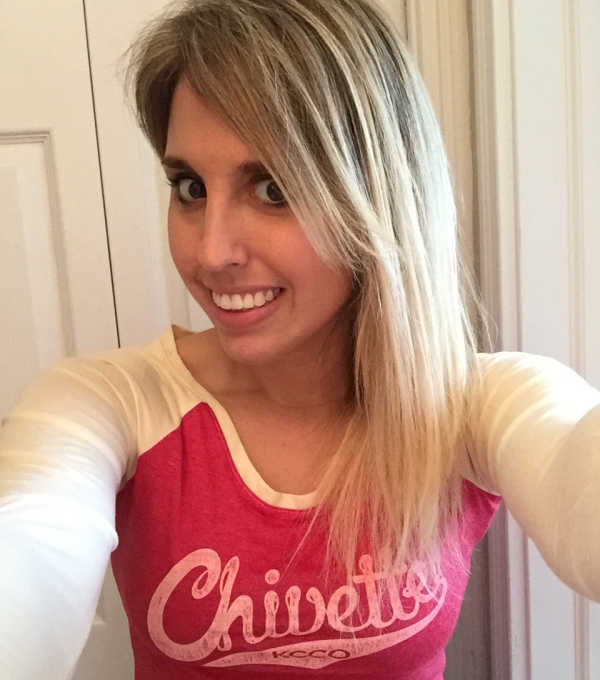 Sexy babe flashes her pearlies, wearing a tee with 'Chivette' written on it.