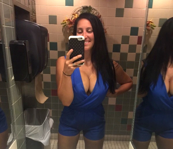 Busty bombshell in blue takes a toilet selfie.
