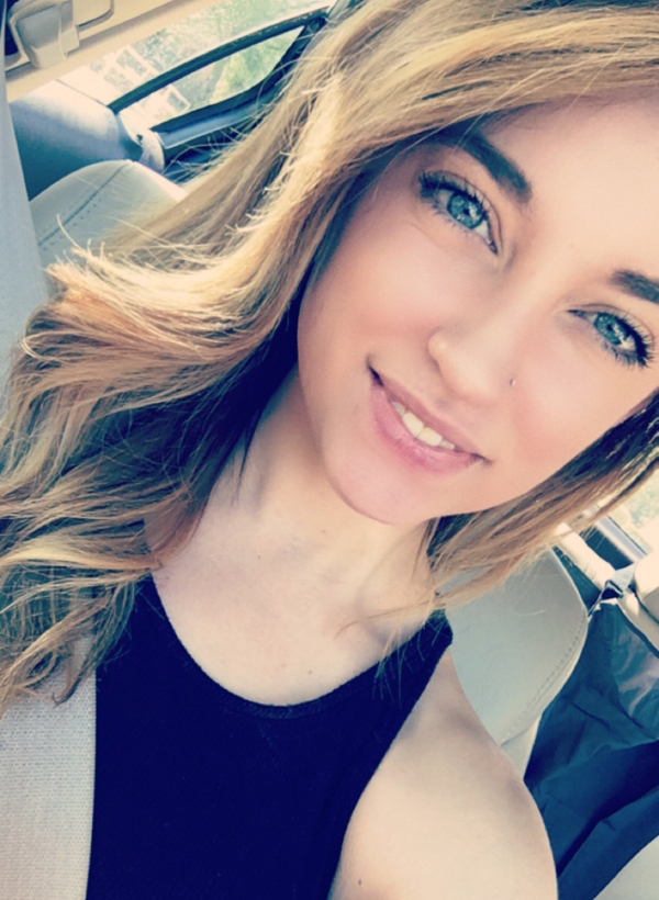 Sexy blonde with blue eyes taking selfie in the car