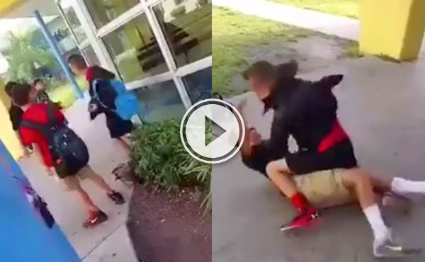 A bully in black shorts and jacket hits another kid with Nike shoes who is sprawled on the ground!