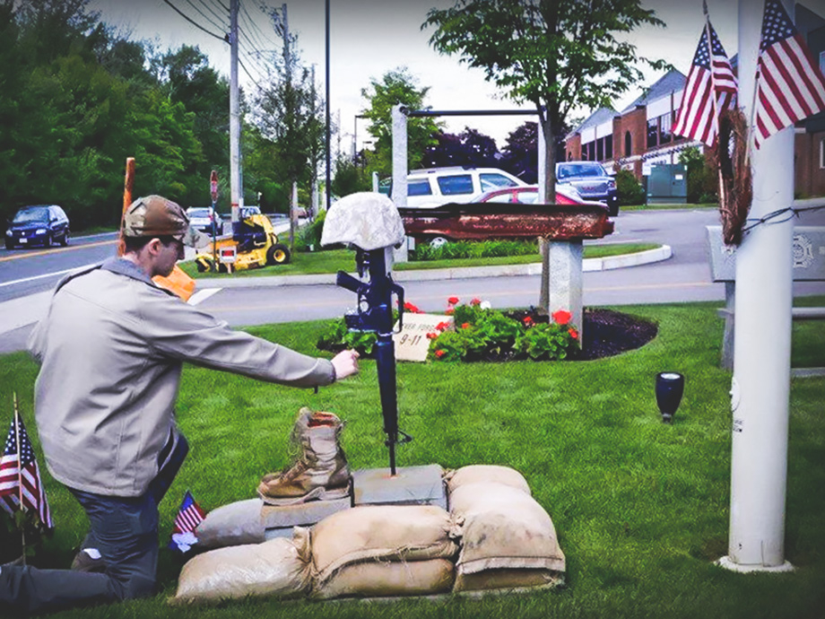 Young guy paying his tribute to the memorial of a late US army veteran, Justin Fitch.