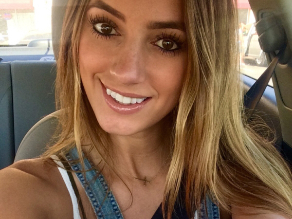Cute blonde with beautiful brown eyes takes a selfie in a car.