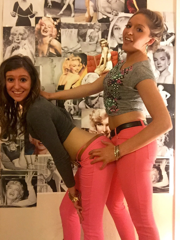 Two sexy blondes wearing pink jeans and gray top looking crazy in fucking posture with marilyn monroe's pictures in background
