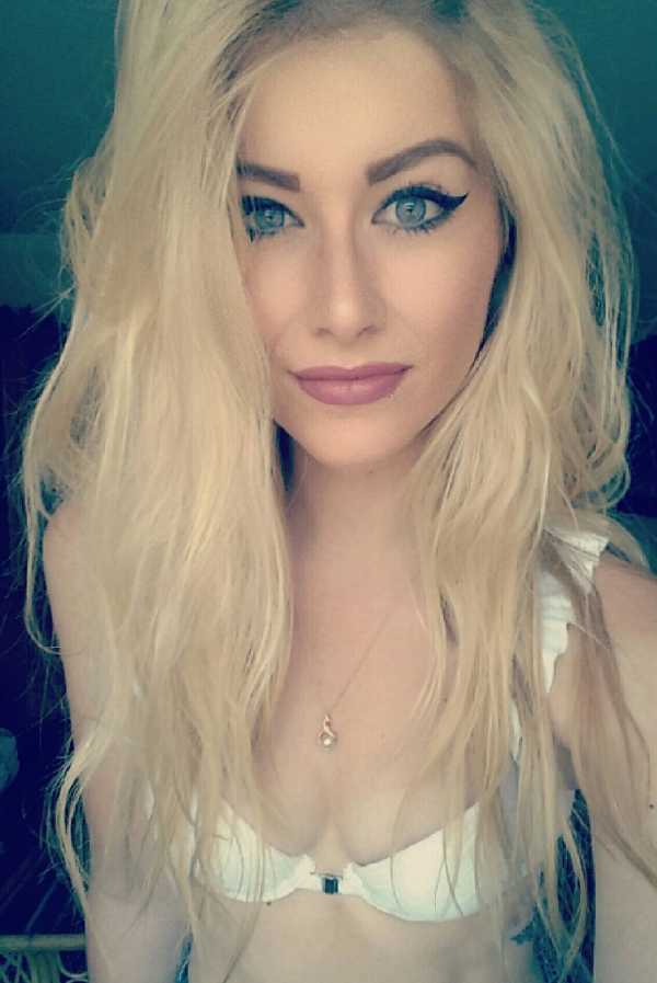 sexy blonde clicks a selfie with open hair, blue eyes and perfectly lined eye liner