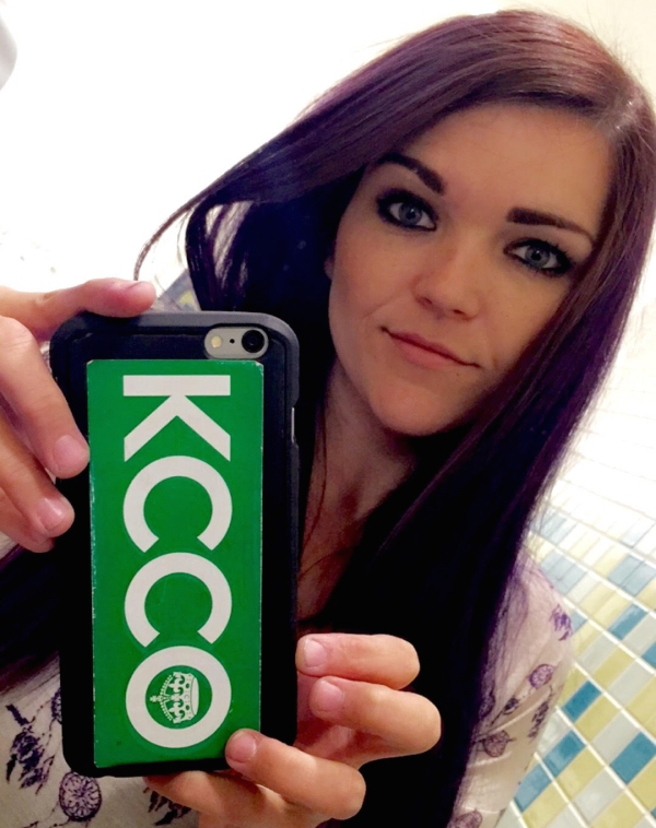Pretty girl clicking selfie with mobile with KCCO phone cover on it