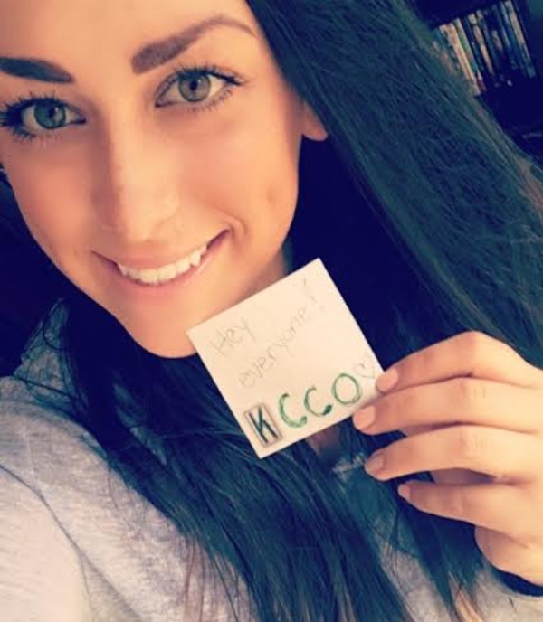 Beautiful girl with open straight hair showing her cleavage with a note with "Chive on" written on it