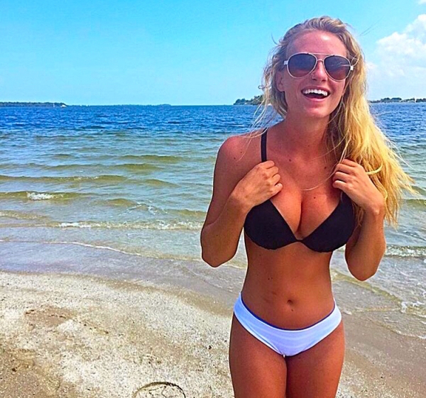 Hot girl in a bikini and shades laughing on the beach