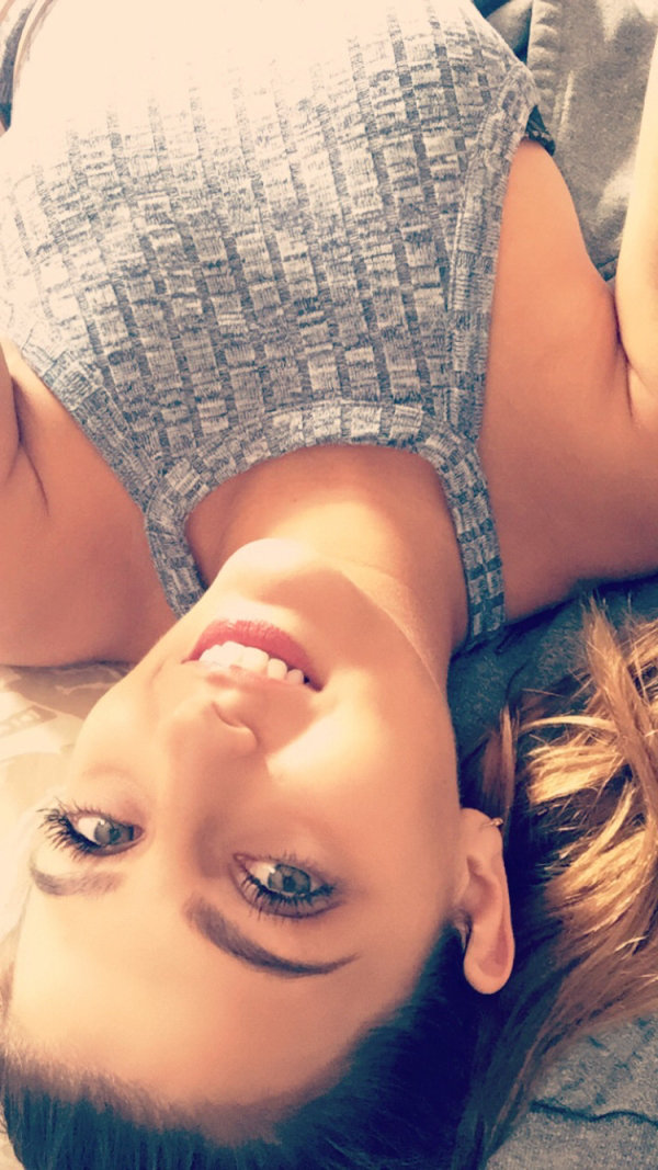 pretty girl taking an upside down selfie of her in a grey