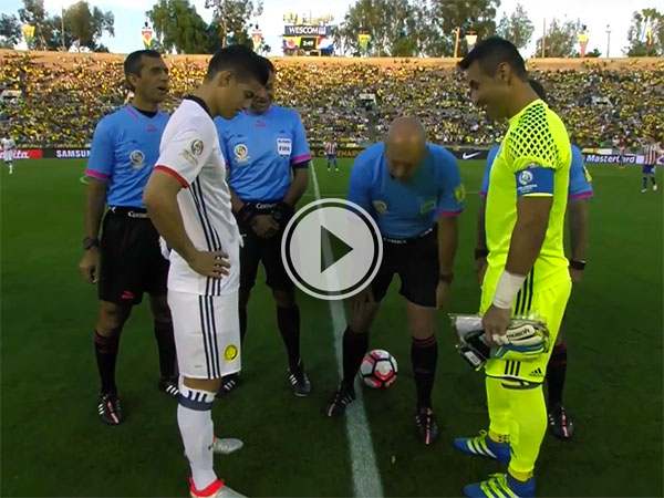 Referee in blue tee and black shorts places the ball to begin a soccer game!
