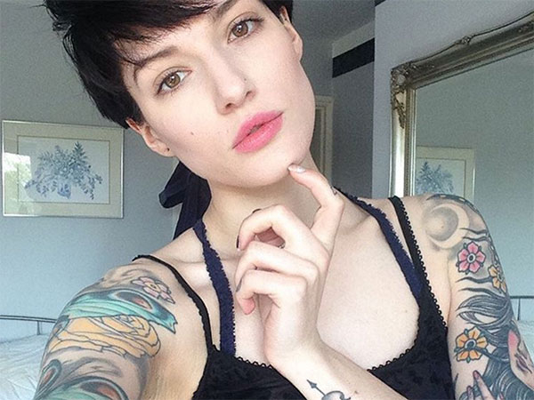 Light-eyed cropped hair brunette with tattoos takes a selfie in black lace top!