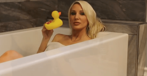 Sexy Blonde draped in a towel making a sexy pout with her toy bath duck
