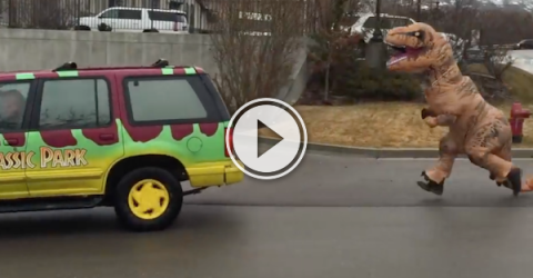 Dude in a T-Rex costume chases a Jurassic Park colored van!