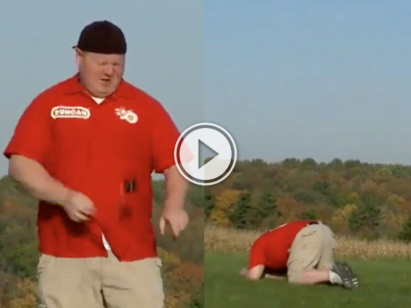An overweight dude in beige shorts and blue shirt kneeling on green grass with his face down!