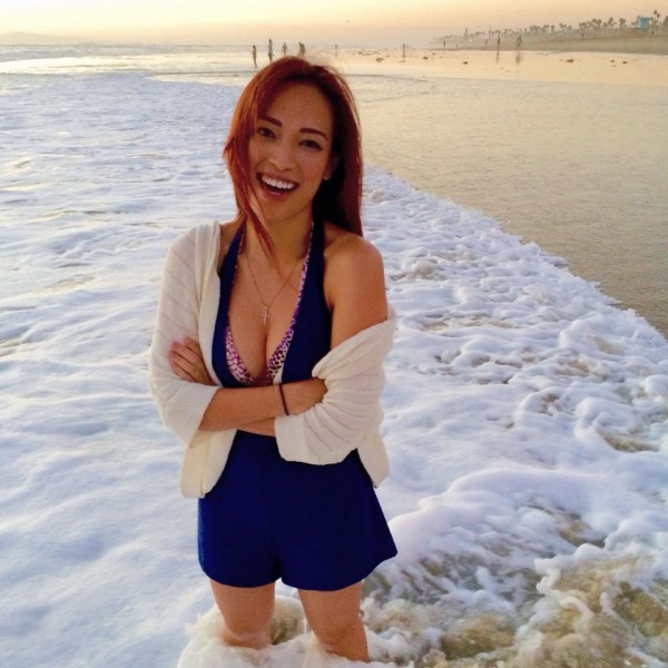 Girl standing and smiling at the beach wearing a white and a blue dress over her bra having big boobs