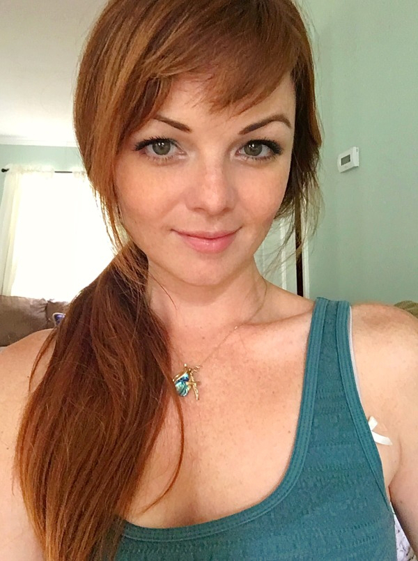 Freckled girl with green eyes wearing a green top clicks a selfie